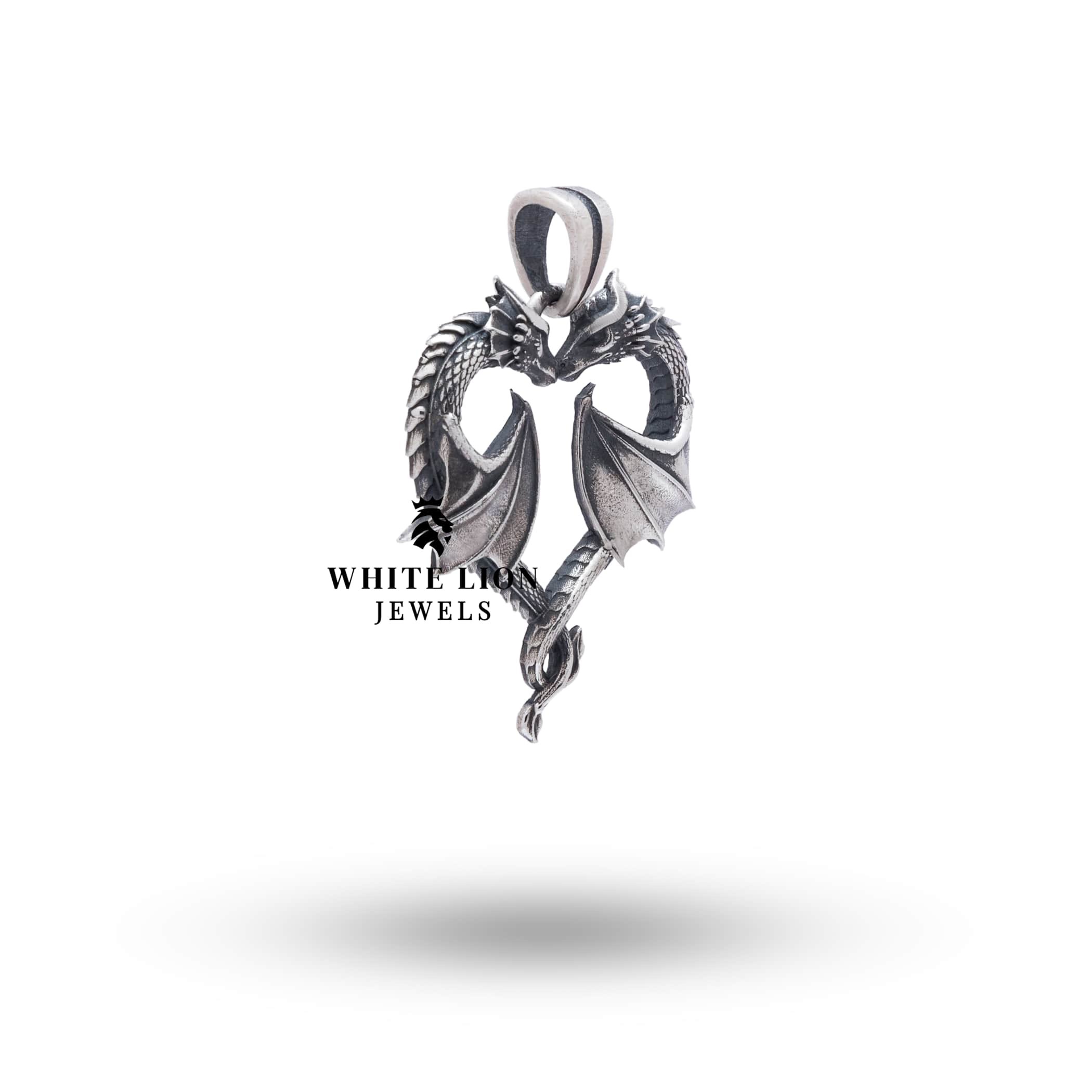 Intricate design of a dragon and heart crafted in sterling silver with a mystical style, by White Lion Jewels.