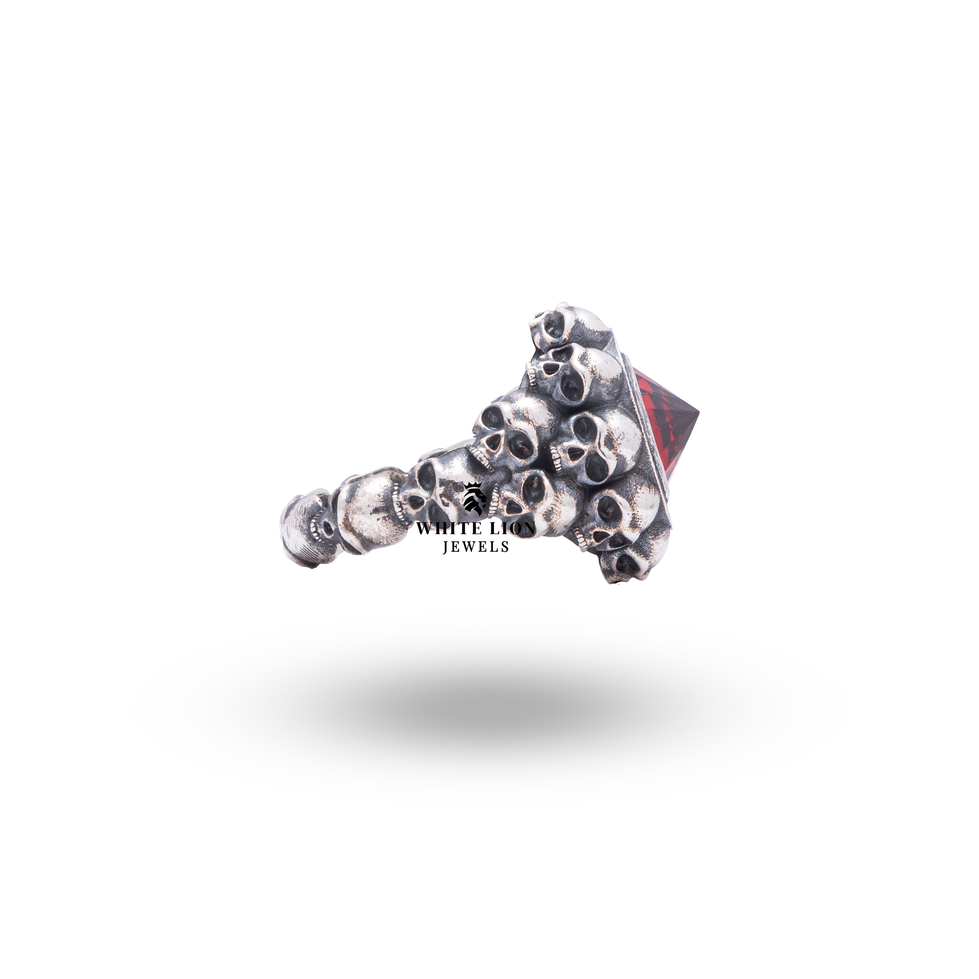 Side angle of sterling silver skull ring featuring garnet stone, demonstrating bold gothic aesthetics.