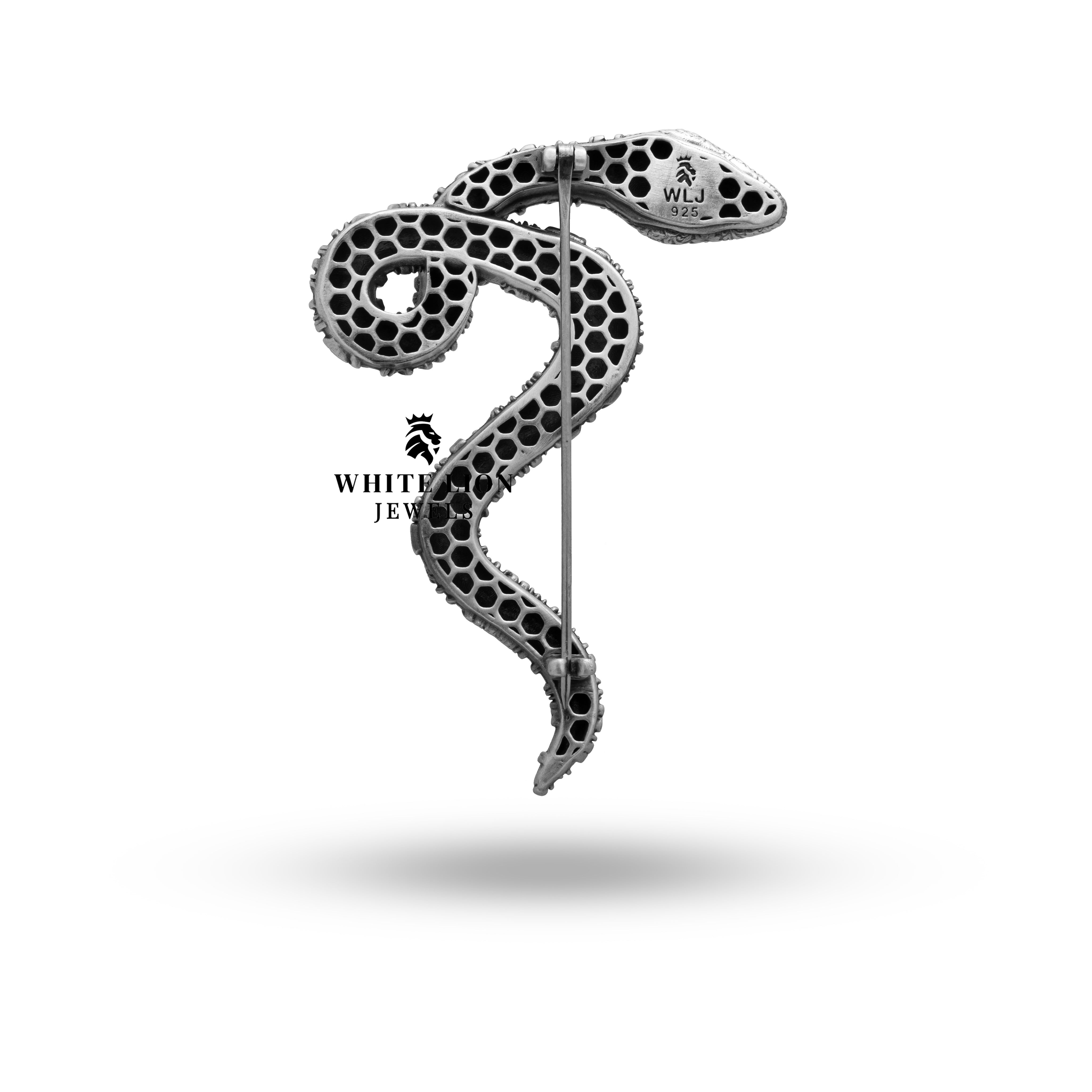 Elegant Snake brooch held in hand showing its detailed design and rich silver color.